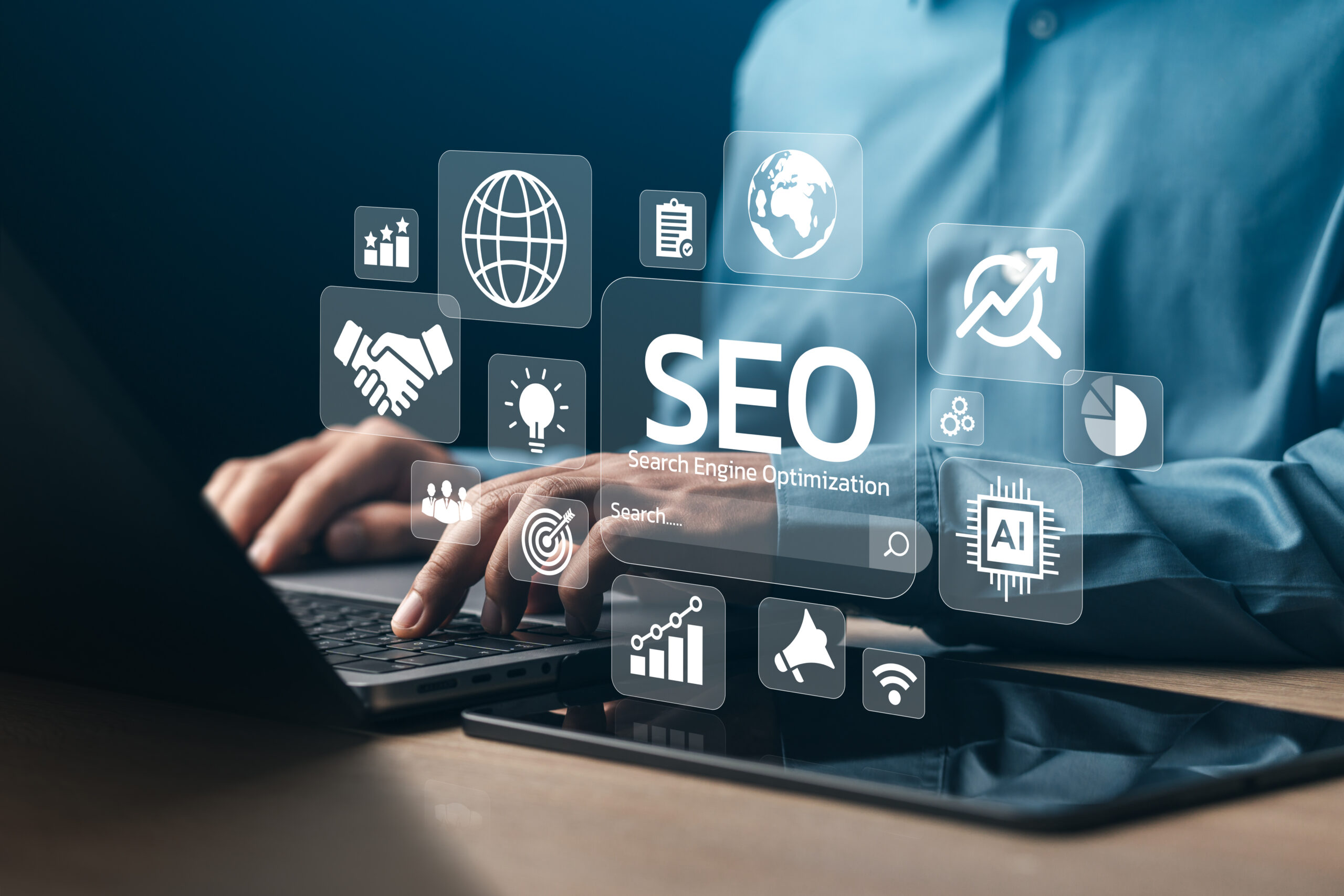 Hender som skriver på en laptop med visuelle ikoner for SEO, datagrafikker og teknologiske symboler svimt over en mørk bakgrunn.