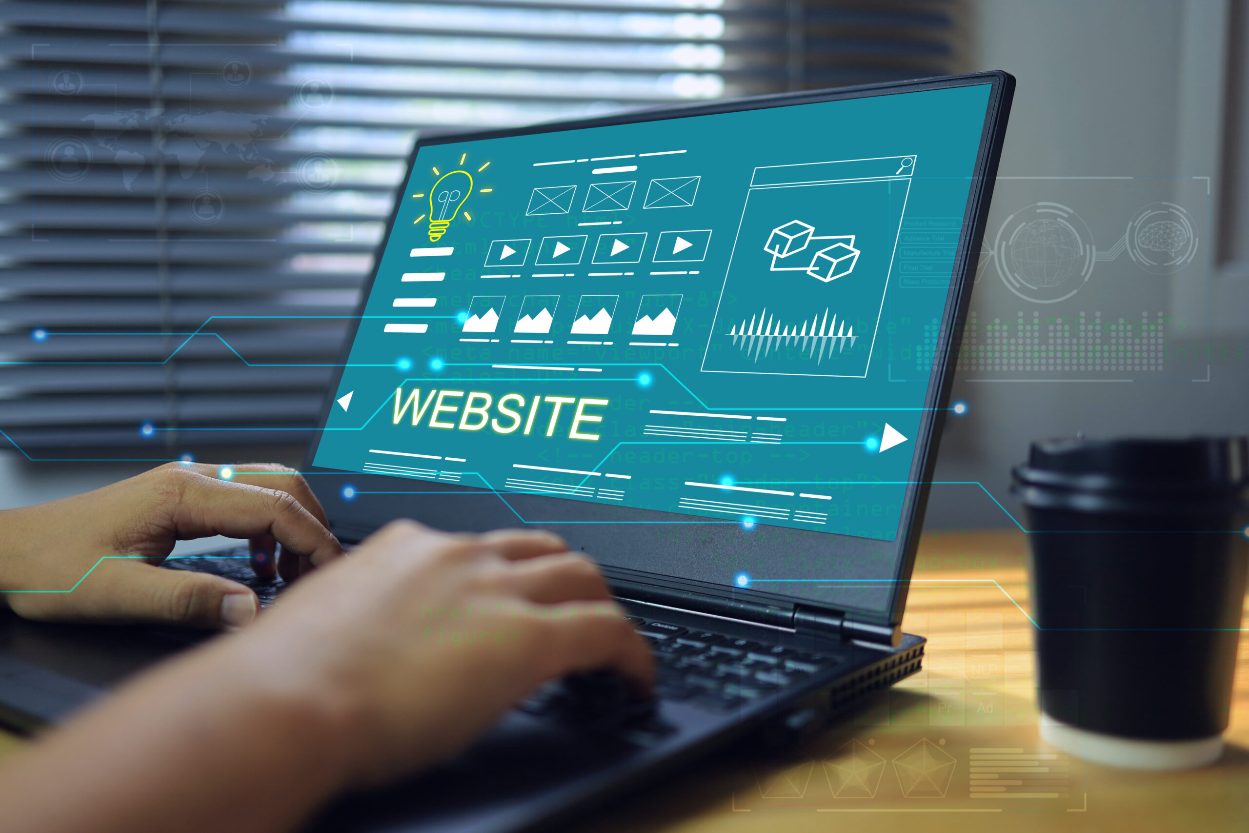 En person skriver på en laptop som viser en blågrønn skjerm med tekst og grafikk relatert til webdesign, med en kaffekopp ved siden av.